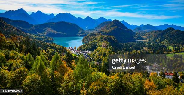 panorama view of alpsee with ammergau alps and hohenschwangau castle in autumn - hohenschwangau germany - bavarian forest stock pictures, royalty-free photos & images