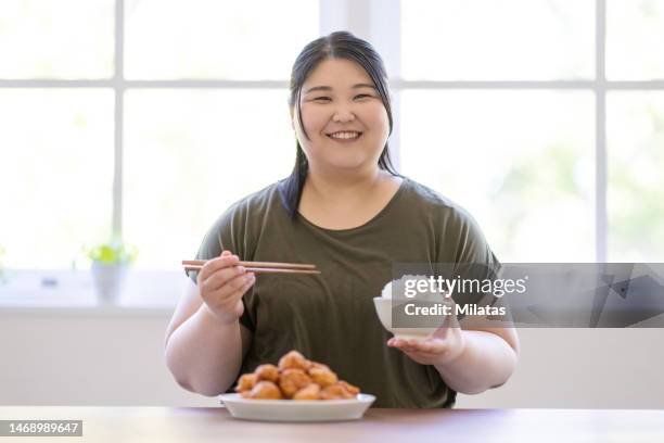 a woman who eats a large bowl of rice - obesity imagens e fotografias de stock