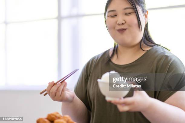 a woman who eats a large bowl of rice - white rice stock pictures, royalty-free photos & images