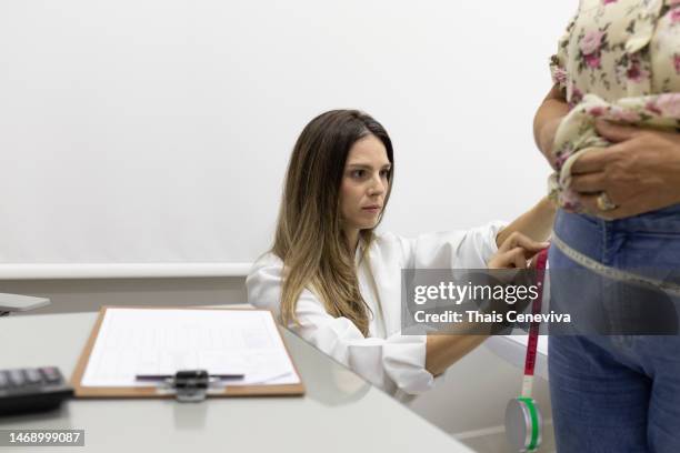 doctor taking measurements of a senior patient using anthropometric tape. - obesity concept stock pictures, royalty-free photos & images