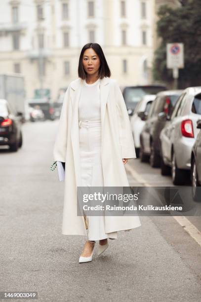 Aimee Song is seen wearing a white cream long wool coat, white tank-top, white long maxi skirt and white pumps outside the Max Mara show during the...