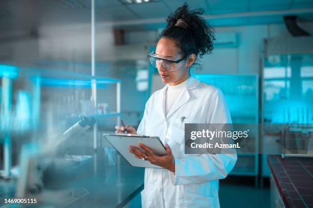 beautiful multiracial female scientist at work - bioquímica imagens e fotografias de stock