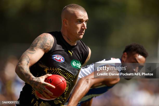 Dustin Martin of the Tigers breaks a tackle from Aiden Bonar of the Kangaroos during the AFL Match Simulation between North Melbourne Kangaroos and...