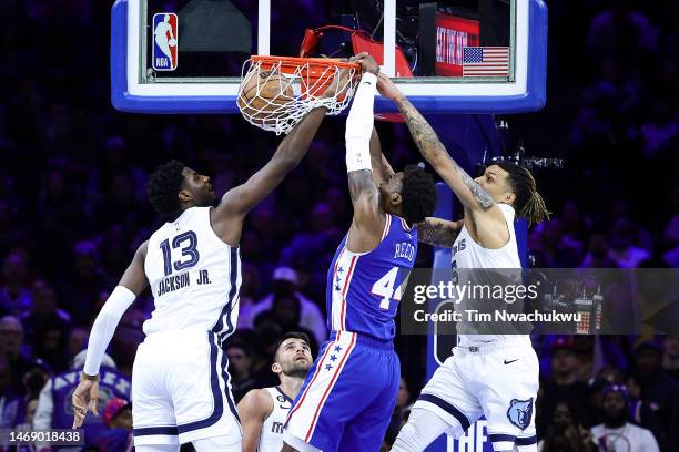 Paul Reed of the Philadelphia 76ers dunks between Jaren Jackson Jr. #13 and Brandon Clarke of the Memphis Grizzlies during the second quarter at...