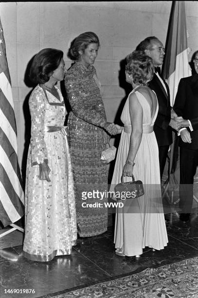 Lise-Marie Sauvagnargues, Nancy Kissinger, guest, and Jean Sauvagnargues attend a party at the National Gallery of Art in Washington, D.C., on...
