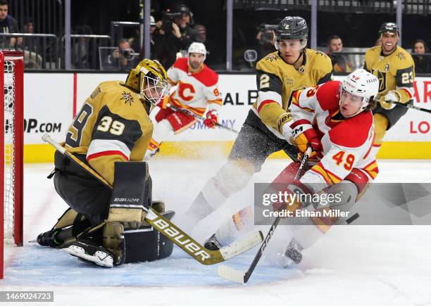 Laurent Brossoit and Zach Whitecloud of the Vegas Golden Knights defend the net against Jakob Pelletier of the Calgary Flames in the first period of...