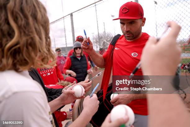 Joey Votto of the Cincinnati Reds signs autographs for fans during a spring training workout at Goodyear Ballpark on February 23, 2023 in Goodyear,...
