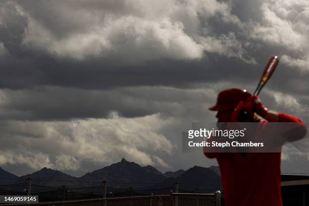 Mountains are seen in the distance as Jake Fraley of the Cincinnati Reds takes batting practice during a spring training workout at Goodyear Ballpark...