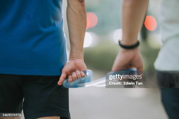 close up asian chinese visually impaired mature man holding running  tether in public park with guide runner - gift guide stockfoto's en -beelden