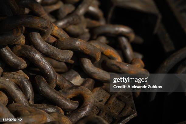 an old rusty iron chain in a boat, close-up. a loop or link of an anchor chain affected by rust. textured and abstract background. industrial industry. faded condition. - molecular weight stock pictures, royalty-free photos & images