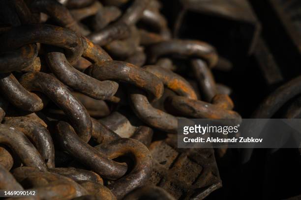 an old rusty iron chain in a boat, close-up. a loop or link of an anchor chain affected by rust. textured and abstract background. industrial industry. faded condition. - rust texture imagens e fotografias de stock
