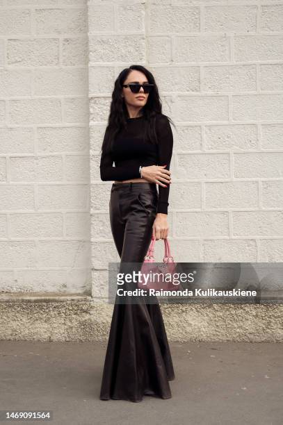 Evangelie Smyrniotaki is seen wearing black flared leather pants, pink Prada bag and see-through crop top outside the Prada show during the Milan...