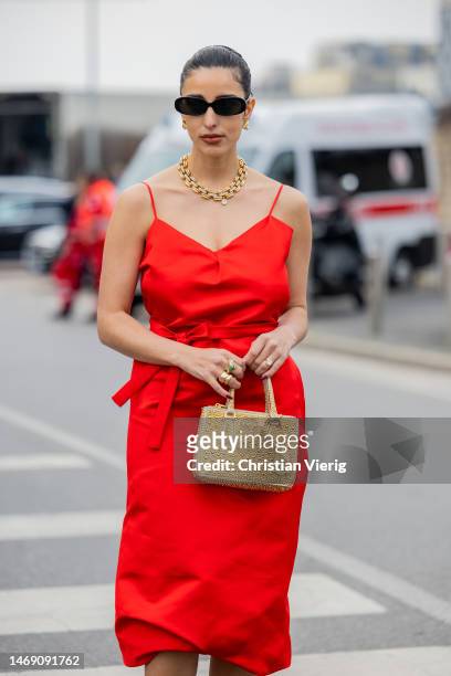 Bettina Looney wears sunglasses, golden necklace, red dress outside Prada during the Milan Fashion Week Womenswear Fall/Winter 2023/2024 on February...
