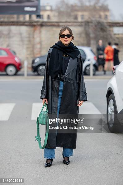 Darja Barannik wears black leather coat, green bag, denim jeans ...
