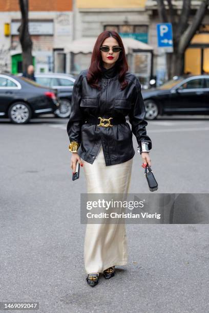 Doina Ciobanu wears black bag, golden belt, black leather jacket, bracelet, satin skirt outside Emporio Armani during the Milan Fashion Week...