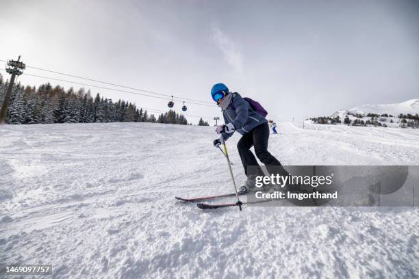 mujer madura esquiando en las montañas de los alpes europeos en austria - skiing fotografías e imágenes de stock