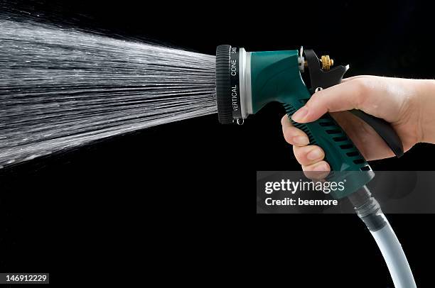 female hand grabbing green water nozzle - hose stock pictures, royalty-free photos & images