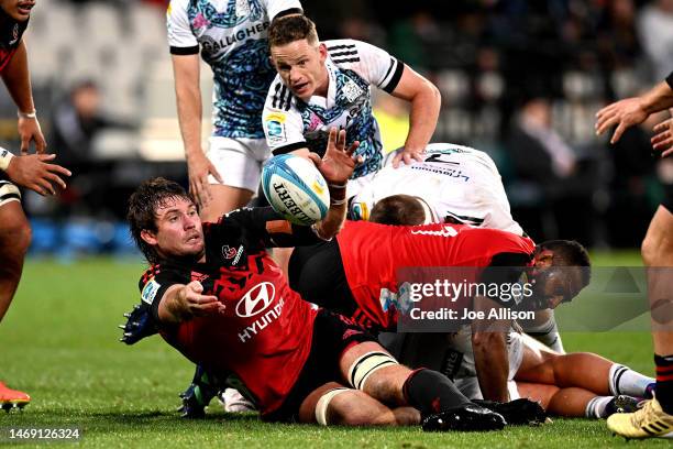 Ethan Blackadder of the Crusaders offloads the ball during the round one Super Rugby Pacific match between Crusaders and Chiefs at Orangetheory...