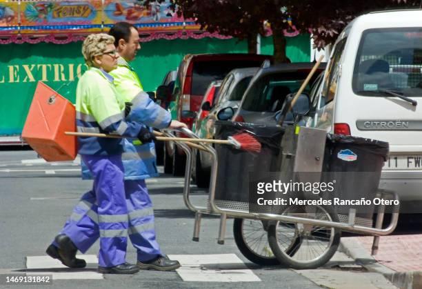 street sweepers pushing cart and equipment. - woman sweeping stock pictures, royalty-free photos & images