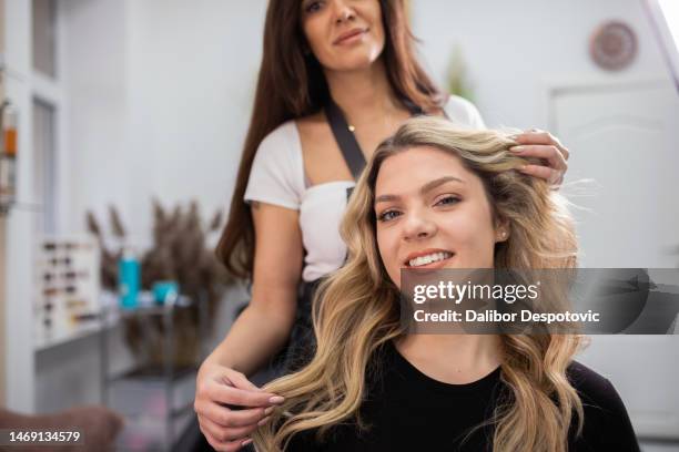 hairdresser blow drying female customers hair in hair salon. - cabeleireiro imagens e fotografias de stock