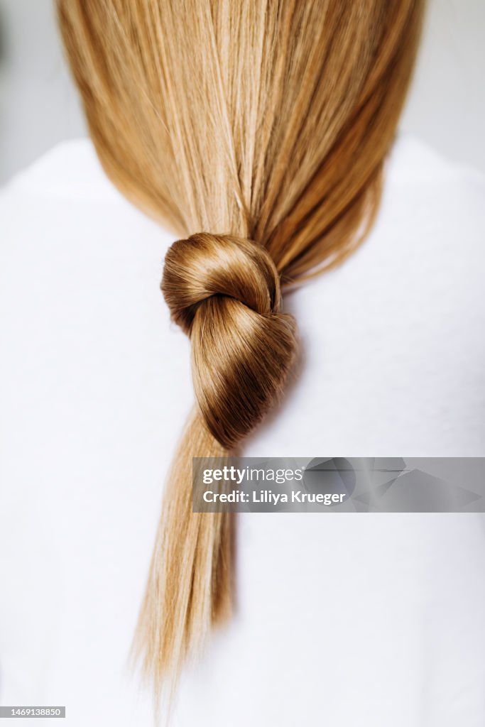 Beautiful healthy long hair tied in a knot.