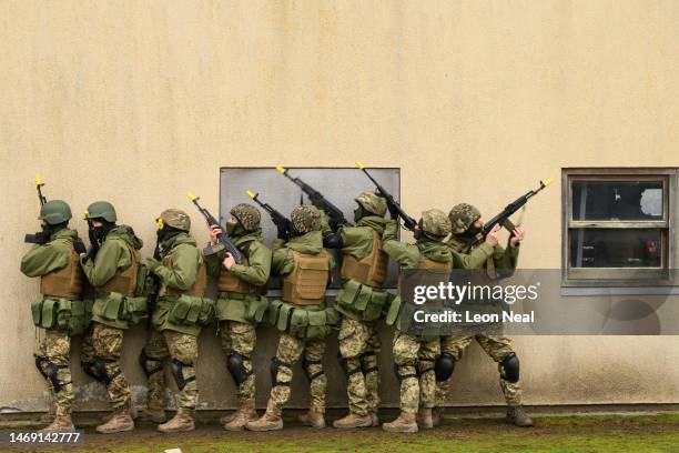 Ukrainian volunteers run through urban warfare training with members of the British Armed Forces at a military camp on February 24, 2023 in South...