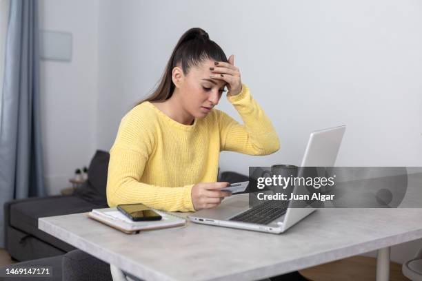 scared woman getting scammed during e commerce - debit card fraud stock pictures, royalty-free photos & images