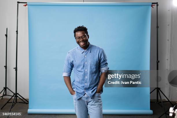 happy black man in jeans at the professional photo studio. - sessão fotográfica imagens e fotografias de stock