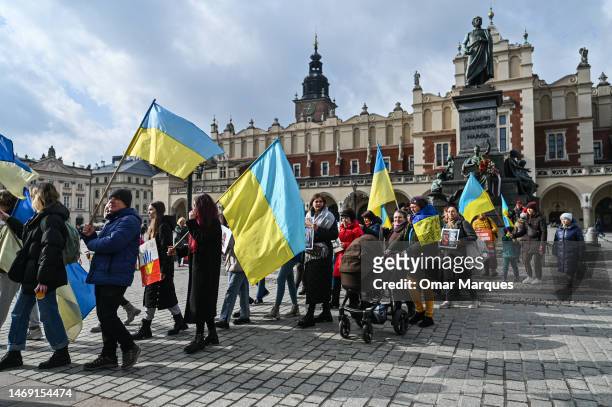 Ukrainians who fled the war and members of the local diaspora hold banners and Ukrainian flags during a daily protest demanding NATO to close the...