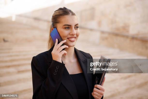 businesswoman using phone on the way to work - malta business stock pictures, royalty-free photos & images