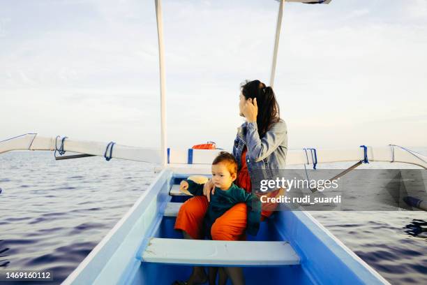 asiatin mit ihrem baby genießen sie den urlaub mit einem ruderboot - baby boot stock-fotos und bilder