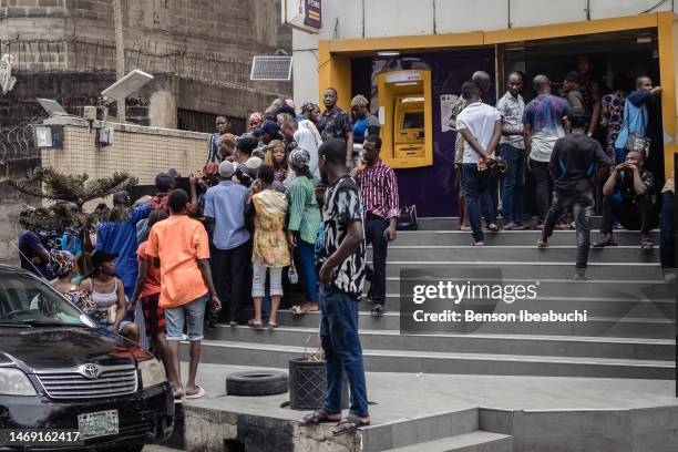 People waiting in front of a bank hoping to withdraw any naira banknotes from inside a bank branch on February 23, 2023 in Lagos, Nigeria. Nigerians...