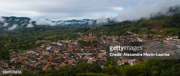 jerico cityscape panoramic view with colonial houses surrounded by green meadows on a cloudy day - antioquia stock pictures, royalty-free photos & images