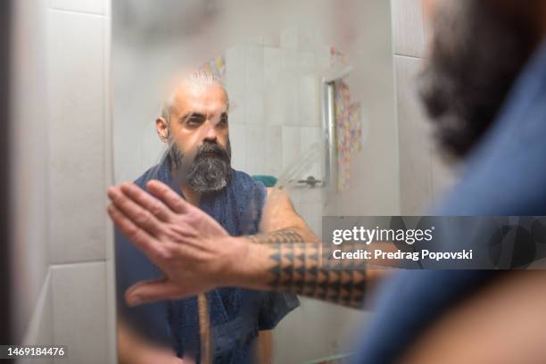 good looking man cleaning mirror steam after shower - steamy mirror stock pictures, royalty-free photos & images