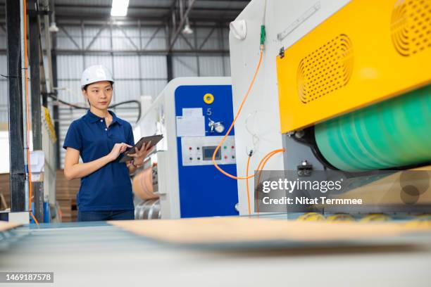 problems and solutions in corrugated box printing process. female quality control and process engineer using a tablet computer to check the printing process by machine learning at large automated inject printer of a corrugated box. - large printer stock pictures, royalty-free photos & images