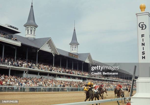 Spectators watch as horses race toward the finish line during the opening day of the Kentucky Derby at Churchill Downs racecourse in in Louisville,...