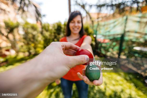 young woman and man egg tapping on easter - broken easter egg stock pictures, royalty-free photos & images