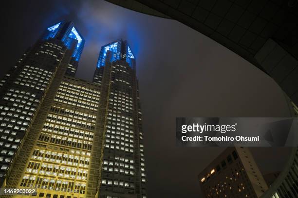 The Tokyo Metropolitan Government building is lit with the Ukraine national flag's colors at night on February 24, 2023 in Tokyo, Japan. Today marks...