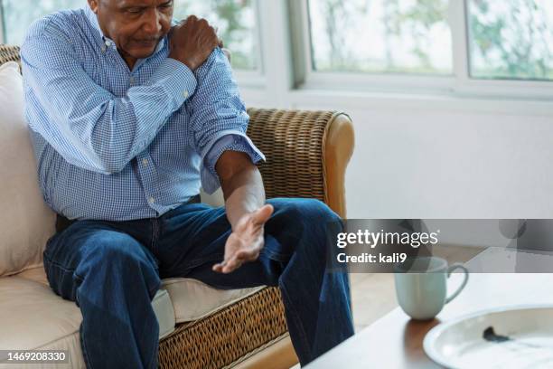 senior african-american man with pain in his shoulder - shoulder stock pictures, royalty-free photos & images