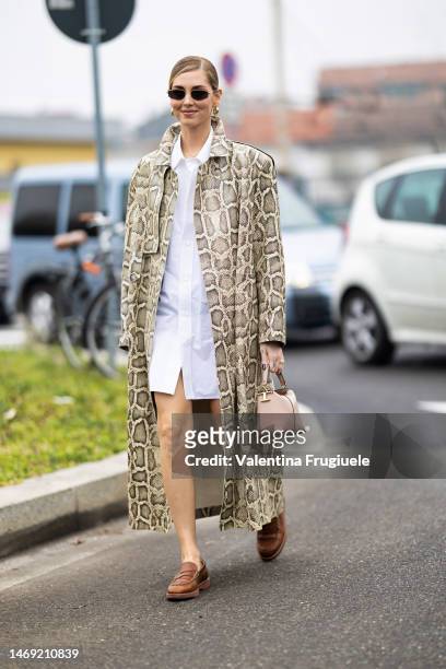 Chiara Ferragni is seen wearing a snakeskin long coat over a button shirt used as a dress, Tod's bag, circle earrings and sunglasses outside the Td's...