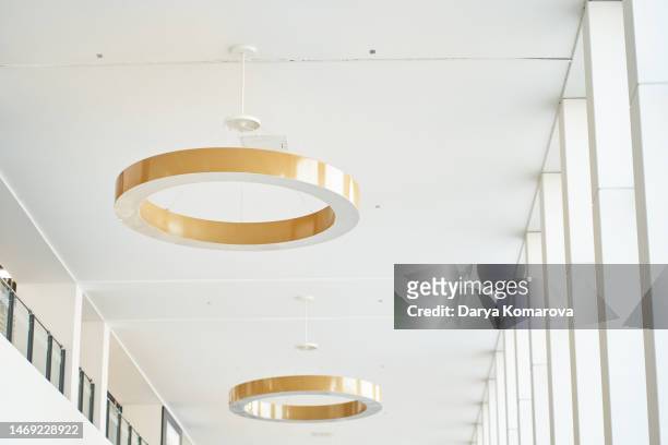 round gold chandeliers on the ceiling - lamps fotografías e imágenes de stock