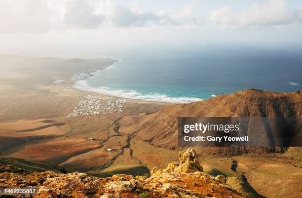 elevated view over coastline and mountains of playa de famara - lanzarote stock pictures, royalty-free photos & images