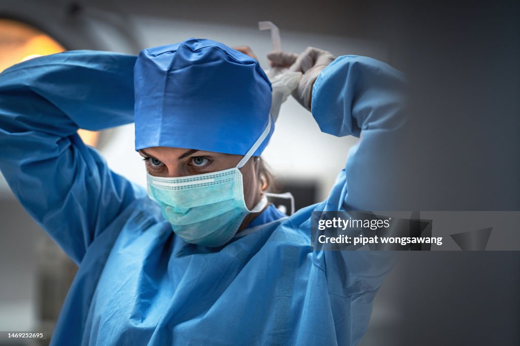The surgeon is wearing a mask to prevent infection before surgery.