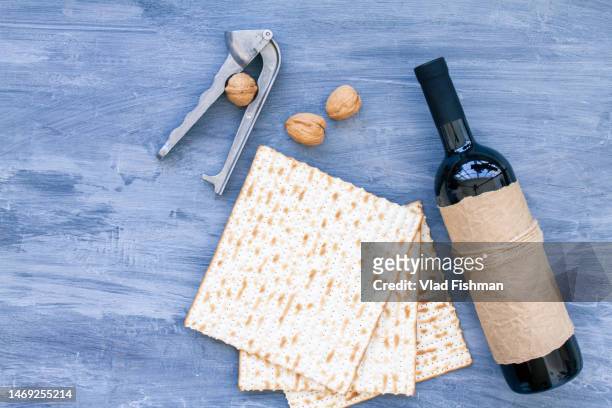 pack of matzah or matza and red kosher wine on a vintage background. jewish passover holiday composition with copyspace - matse stockfoto's en -beelden