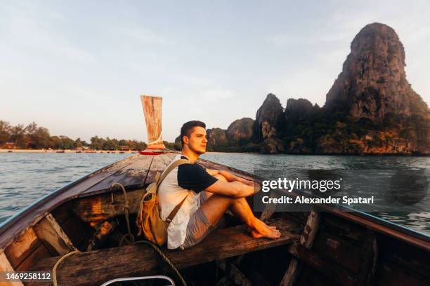 man exploring thailand beaches on a longtail boat, krabi, thailand - the isle of man tt races stockfoto's en -beelden