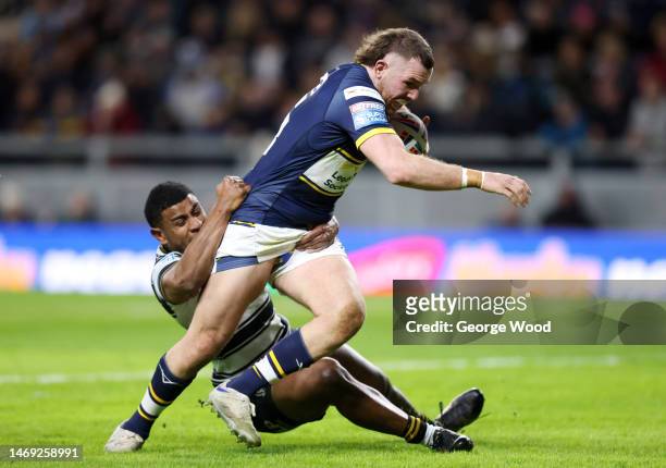 Cameron Smith of Leeds Rhinos breaks through the tackle of Joe Lovodua of Hull FC to score the team's first try during the Betfred Super League match...