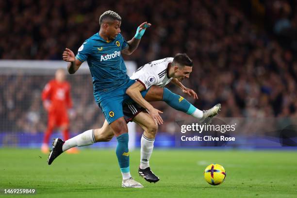 Joao Palhinha of Fulham is tackled by Mario Lemina of Wolverhampton Wanderers during the Premier League match between Fulham FC and Wolverhampton...