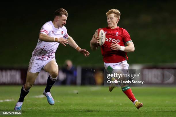 Harri Houston of Wales is runs with the ball whilst under pressure from Tobias Elliot of England during the U20 Six Nations Rugby match between Wales...