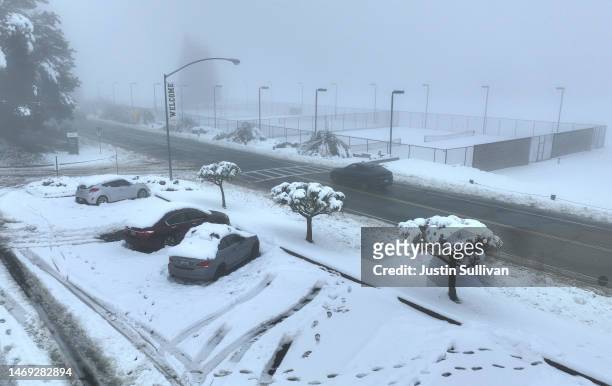 In an aerial view, cars are seen covered in snow at Pacific Union College on February 24, 2023 in Angwin, California. A large winter storm brought...