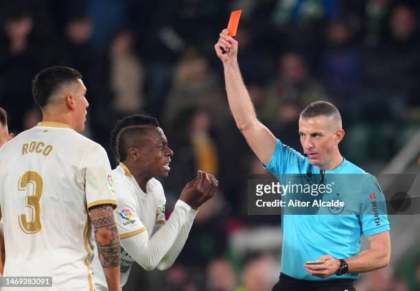 Referee David Iglesias Gutierrez shows a red card to Enzo Roco of Elche CF during the LaLiga Santander match between Elche CF and Real Betis at...